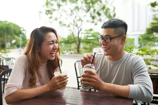 Vietnamese young couple laughing and joking when having a date